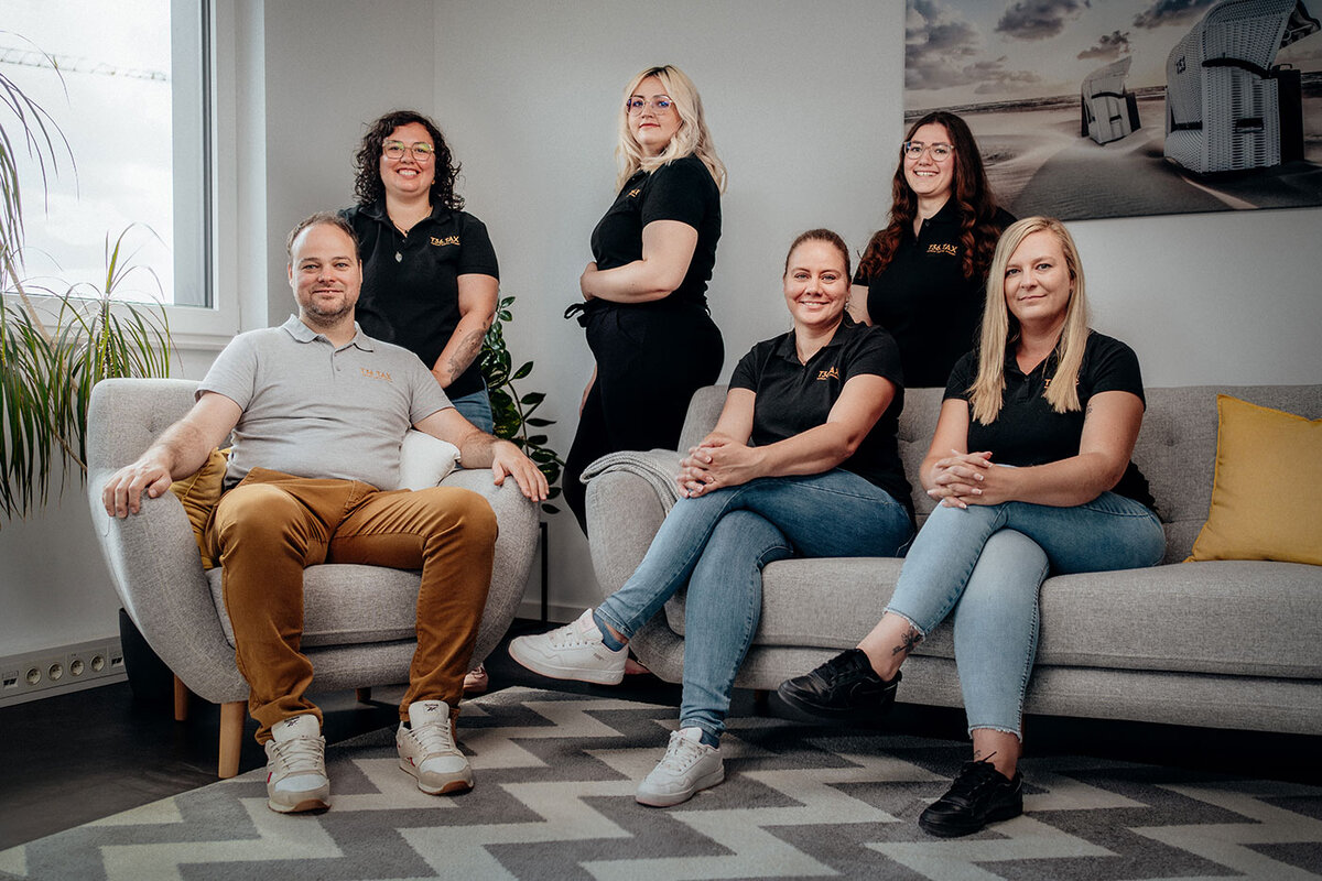 Team einer Steuerkanzlei im Büro, Gruppenbild auf Sofa und Sessel